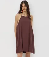 Enterito corto de viscosa color salmón con diseño de cuello halter, espalda abierta y caída fluida.