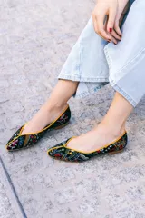 Bailarinas negras con estampado multicolor y ribete naranja.