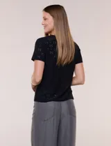 Remera blanca de calce recto con diseño de bordado calado estilo broderie, cuello redondo clásico y mangas cortas.