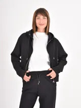 Campera negra con capucha, cierre frontal completo y cordones ajustables. Presenta un diseño liso y funcional con bolsillos laterales.