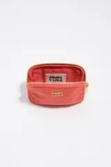 Monedero coral de Bimba y Lola con cierre de cremallera metálica dorada, detalle de logotipo metálico en el frente y bolsillo interior.