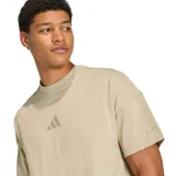 Remera de algodón color beige con cuello redondo acanalado, corte holgado y logo de Adidas bordado en el centro del pecho.