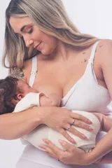 Soutien maternal sin aro, color blanco, diseñado con doble clip en los breteles para facilitar la lactancia y el uso de extractor. Presenta un escote alto, breteles elásticos regulables y cierre de broches en la espalda.