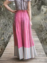 Falda larga de lino con estampado a rayas verticales en tonos rosados, fucsias y marrones.