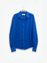 Camisa de manga larga confeccionada 100% en lino, color verde claro, con calce recto y relajado. Presenta frente abotonado con botones de coco con logo y el patch característico de Polonio.