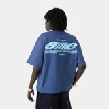 Remera oversize de color azul, confeccionada en algodón puro, de manga corta y cuello redondo acanalado. Presenta un amplio estampado gráfico en la espalda en tonos celestes con inscripciones tipográficas.