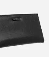 Billetera sobre mediana Satinato de color negro, confeccionada en poliuretano con acabado brillante. Presenta diseño plegable, cierre con botón interno, bolsillo externo con cierre y tirador alargado. Incluye placa metálica decorativa con las siglas de la marca.