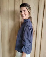 Blusa de algodón con cuello mao y volados, mangas largas con puños elásticos y corte holgado.