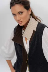 Chaleco de punto de lambswool color marrón, con cierre frontal y cuello alto en combinación de color gris y negro.