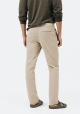Pantalón de vestir color verde oscuro, de corte slim, con bolsillos laterales y traseros. Se ajusta a la cintura con botón y cierre.