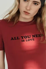 Camiseta de algodón de corte regular, con cuello redondo y manga corta. Presenta un estampado con texto a contraste en el frente y bajo recto.