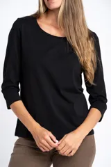 Remera de algodón con elastano, color negro, con mangas 3/4 y cuello redondo. Presenta un calce al cuerpo y está confeccionada en algodón peinado suave y resistente.