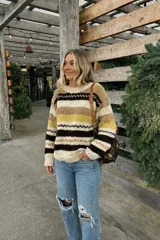 Sweater de lana merino con estampado Fair Isle en tonos azul marino, beige, naranja, verde oliva y bordó. Tiene cuello redondo y mangas largas.