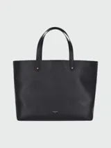 Bolso tote negro de cuero liso, con dos asas superiores y herrajes dorados. Presenta un pequeño logo dorado en la parte inferior central.