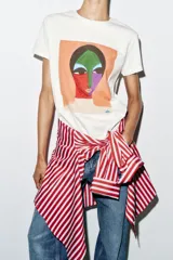 Camiseta blanca de manga corta y cuello redondo, de corte regular con estampa frontal artística y colorida de un rostro estilo abstracto.