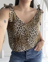 Blusa con estampado animal print, escote en V y tiras con nudo en los hombros.