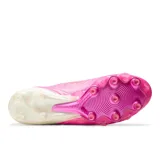 Championes de fútbol New Balance modelo Tekela, color fucsia con detalles en blanco y logo dorado. Presentan un diseño de corte bajo con estructura tejida y suela con tapones para césped natural.