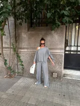 Pantalón de lanilla color beige, de corte recto y tiro alto, con diseño holgado y fluido.