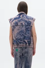 Chaleco de jean azul con efecto lavado, corte oversized y bolsillos delanteros.