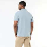 Remera polo de piqué de algodón color celeste, con cuello y puños acanalados, y cierre frontal de tres botones.