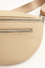 Riñonera color beige con correa ajustable.