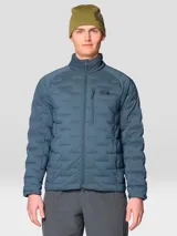 Campera técnica acolchada de plumón, color azul, con cierre frontal de dos vías, cuello alto, bolsillo en el pecho con cierre y bolsillos laterales. Presenta una construcción elástica tejida que permite mayor libertad de movimiento.