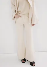 Jeans de algodón tiro medio, diseño acampanado estilo flare de corte largo, con trabillas, cinco bolsillos y cierre frontal de botón y cremallera.