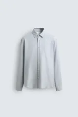 Camisa de corte regular fit confeccionada en una mezcla de algodón y lana. Presenta cuello solapa, manga larga con puños abotonados y cierre frontal con botonadura.