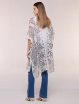 Kimono confeccionado en algodón ligero con diseño estampado de arabescos en tonos marrones sobre base beige, de corte suelto y envolvente con mangas amplias.