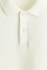 Remera polo de punto jacquard de mezcla de algodón, color blanco, de manga corta, con cuello clásico y tapeta corta de botones. Corte entallado.