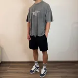 Short de algodón gris melange con cintura elástica y cordón de ajuste, de corte holgado y ruedo sin costura.