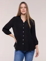 Blusa celeste de silueta suelta y textura liviana, con escote en V, cuello mao y cierre frontal de botones. Cuenta con alforzas verticales en el pecho y mangas tres cuartos con puños elastizados y detalle de galón calado.