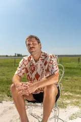 Camisa de manga corta con estampado abstracto en tonos naranja y blanco, cuello americano y botones de madera.