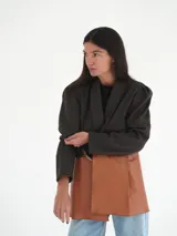 Blazer gris oscuro de lana con solapas amplias, corte entallado y mangas 3/4 con hombreras.