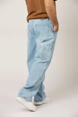 Jean de corte baggy en denim color celeste claro, con diseño de paneles reforzados en la parte frontal y estilo cargo con bolsillos laterales.