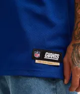 Remera deportiva azul con tecnología Dry, cuello en V, manga corta con estampado lettering y rayas contrastantes, estampado lettering NFL Giants.