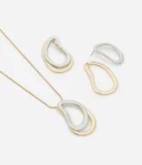 Conjunto de collar con cadena fina dorada y colgante con forma orgánica bicolor (dorado y plateado) y aros con forma orgánica bicolor (dorado y plateado).