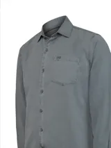 Camisa de manga larga RKF en color gris, confeccionada en una mezcla de tencel y lino. Presenta un diseño minimalista con cuello clásico, cierre frontal de botones y un bolsillo en el pecho con el logo de la marca bordado.
