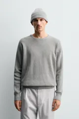 Jersey de punto con textura acanalada, cuello redondo y manga larga. Presenta un corte regular fit con acabados en rib en puños y bajo.