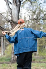 Campera de denim azul de corte oversize, con cuello, cierre frontal, bolsillos laterales amplios y ajuste en puños y bajo.