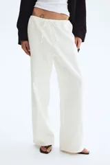 Pantalón de corte holgado en denim liviano de mezcla de lyocell y algodón. Modelo de tiro alto con elástico revestido y cordón para ajustar en la cintura, bolsillos laterales discretos y piernas rectas.