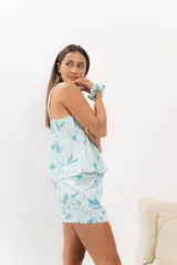 Pijama de seda estampada con diseño floral en tonos celestes y blancos. Incluye una musculosa con escote en V y espalda recta, y un short con elástico en la cintura.