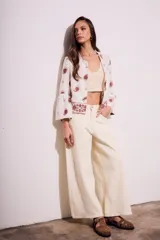 Blusa blanca con bordado de cachemir en negro, corte oversize y mangas acampanadas.