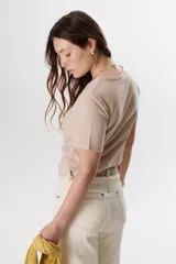 Remera lisa de color beige, con escote en V y mangas cortas de corte clásico.