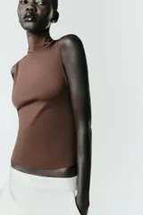 Camiseta sin mangas de cuello subido, con ajuste entallado al cuerpo.