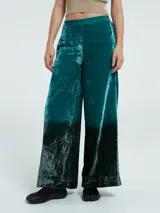 Pantalón palazzo de terciopelo verde esmeralda con efecto degradado a negro en la parte inferior.