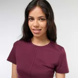 Remera de punto de canalé color borgoña, de corte ajustado, con cuello redondo y mangas cortas. Presenta una costura vertical central en el frente y una pequeña abertura en el ruedo.