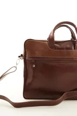 Portafolio de cuero vacuno marrón, con doble asa superior, correa ajustable desmontable y bolsillo frontal con cierre. Presenta detalles de textura símil reptil en la parte superior.