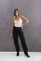 Pantalón de vestir color negro, de corte holgado y cintura de altura media. Presenta pinzas frontales, bolsillos con solapa decorativa y bolsillos traseros tipo ojal.