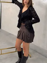 Short pollera de tiro alto en color marrón chocolate, con diseño de volado en el ruedo y ajuste elástico en la cintura.